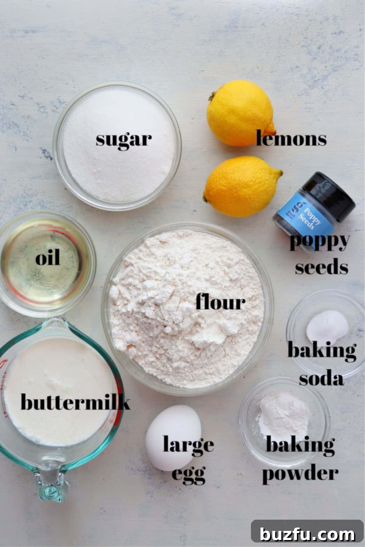 Assortment of fresh ingredients for lemon poppy seed muffins laid out on a wooden board.