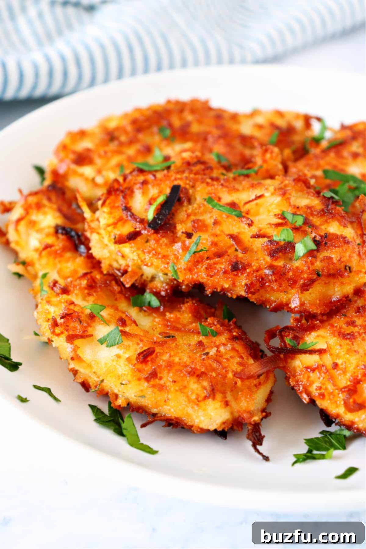 Best Crispy Coconut Chicken Recipe Crispy golden-brown coconut chicken pieces arranged appealingly on a plate, garnished with fresh herbs, ready to be served.