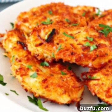 Golden Coconut Chicken 3 Coconut chicken pieces on a plate, showcasing their crispy golden exterior.