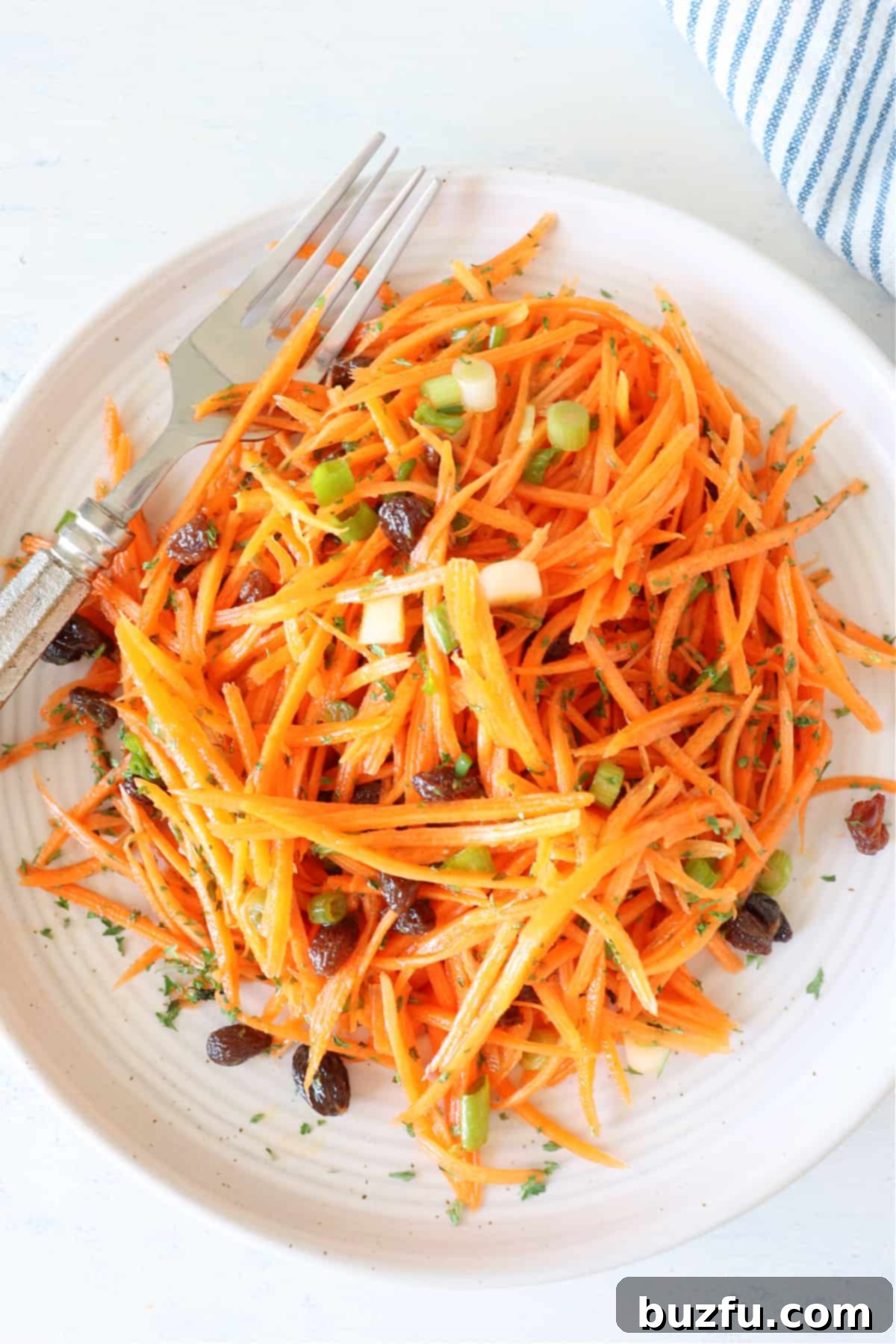 Fresh Carrot Salad Recipe with Honey Vinaigrette Carrot salad on a plate with fork, showcasing vibrant colors and fresh ingredients.