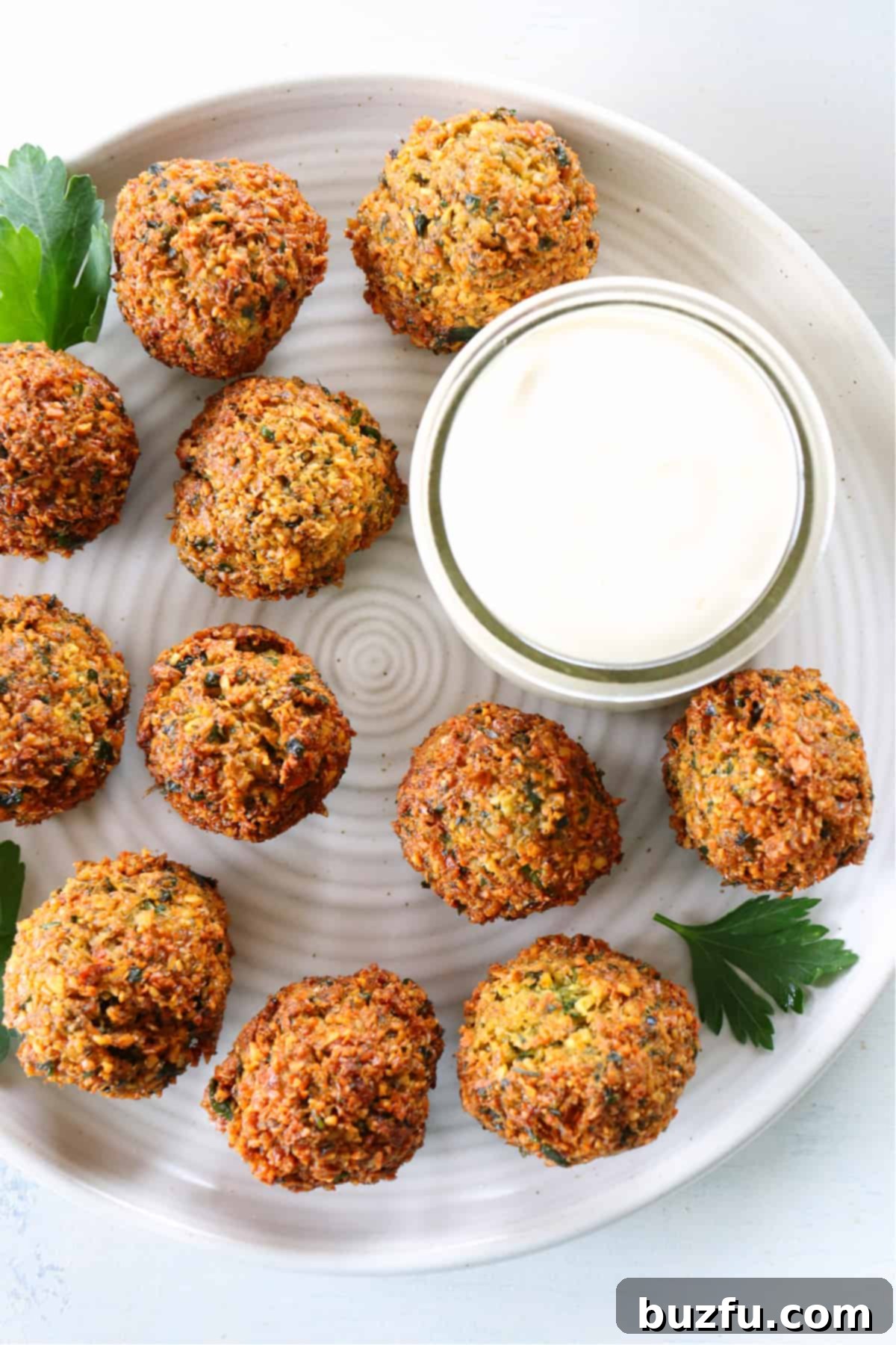 Easy Falafel Recipe Fried falafel with sauce on a plate.