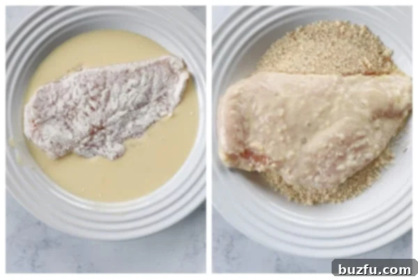 Breading chicken cutlets step-by-step Two pieces of chicken breast in different stages of breading: one fully coated in egg wash and another being pressed into bread crumbs in separate shallow dishes.