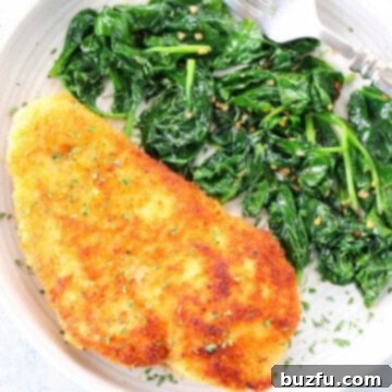 Crispy Chicken Cutlets 3 Breaded chicken and sauteed spinach on plate.