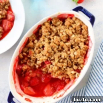 Freshly baked strawberry crumble in an oval baking dish.