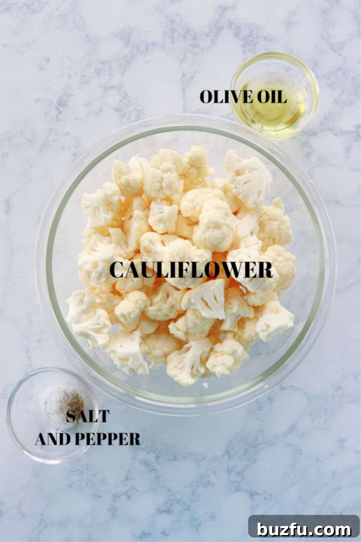 Fresh cauliflower, olive oil, salt, and pepper laid out as ingredients for air fryer cauliflower.