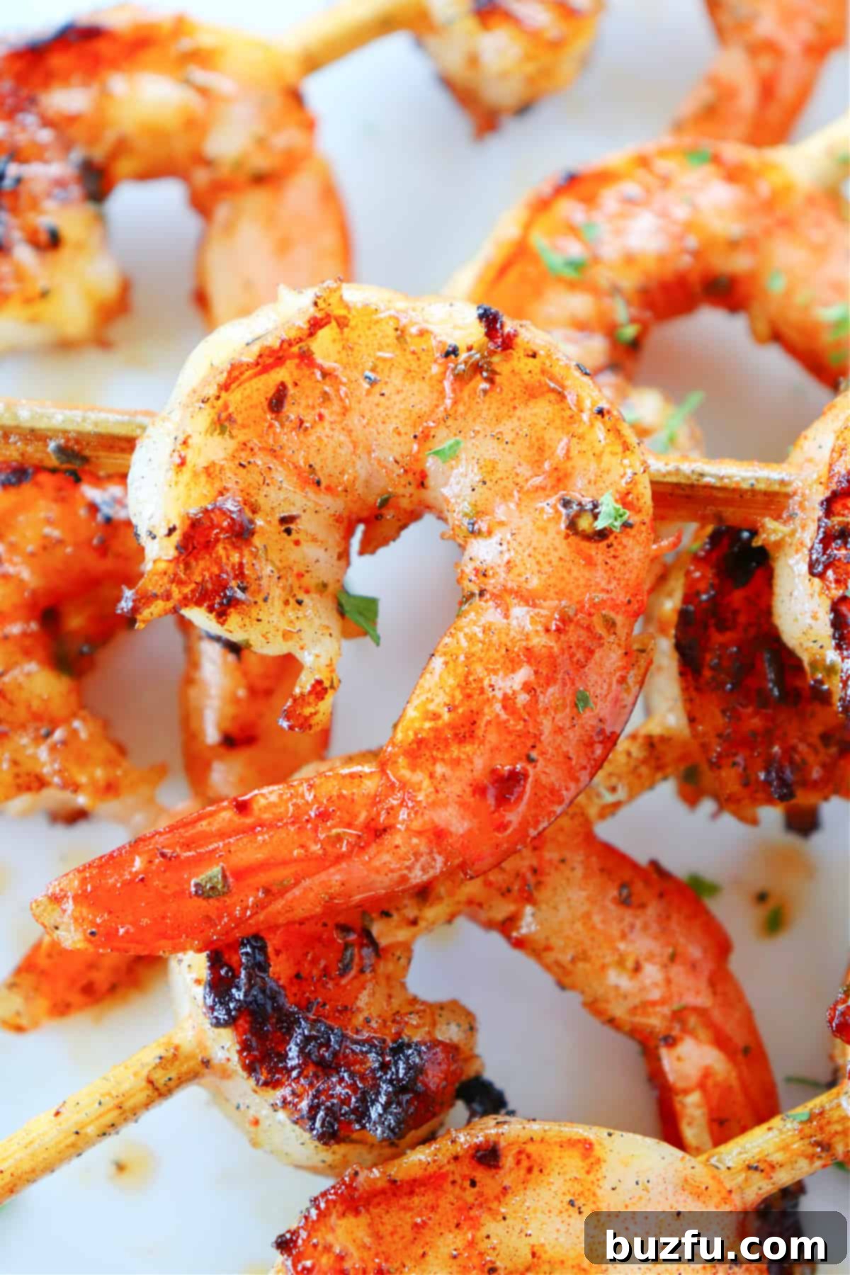 Grilled shrimp skewers on a plate, garnished with fresh herbs, ready to be served.