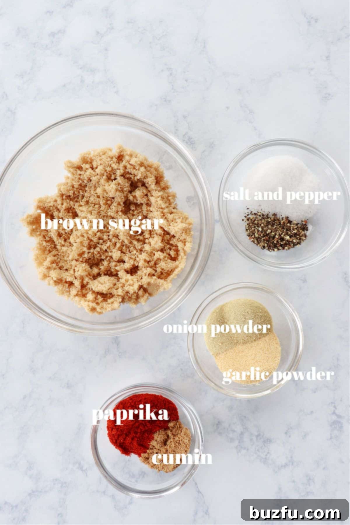 Dry Rub Ingredients Individual ingredients for the dry rub, including brown sugar, paprika, salt, pepper, garlic powder, onion powder, and cumin, neatly arranged in small bowls.