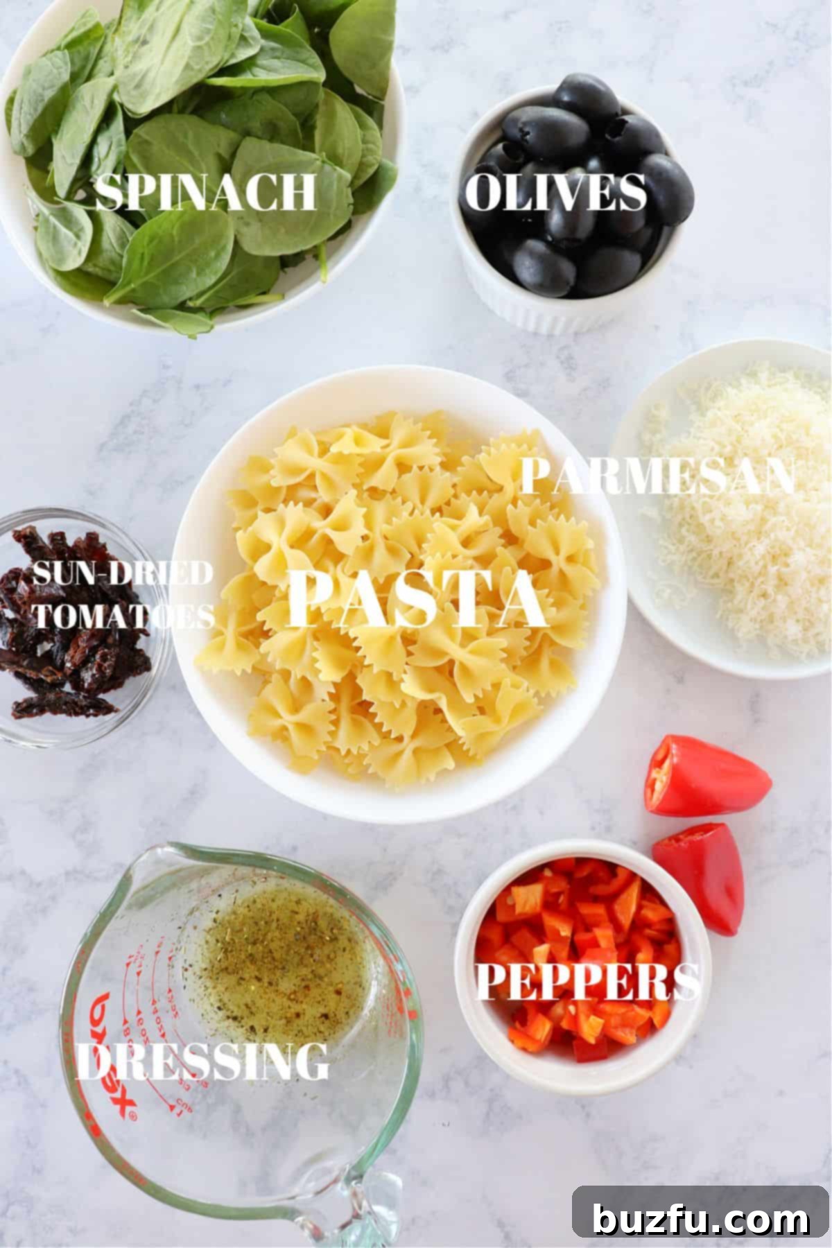 Fresh Ingredients for Tuscan Pasta Salad A beautiful arrangement of fresh ingredients for Tuscan pasta salad on a rustic marble board, showcasing their vibrant colors and textures.