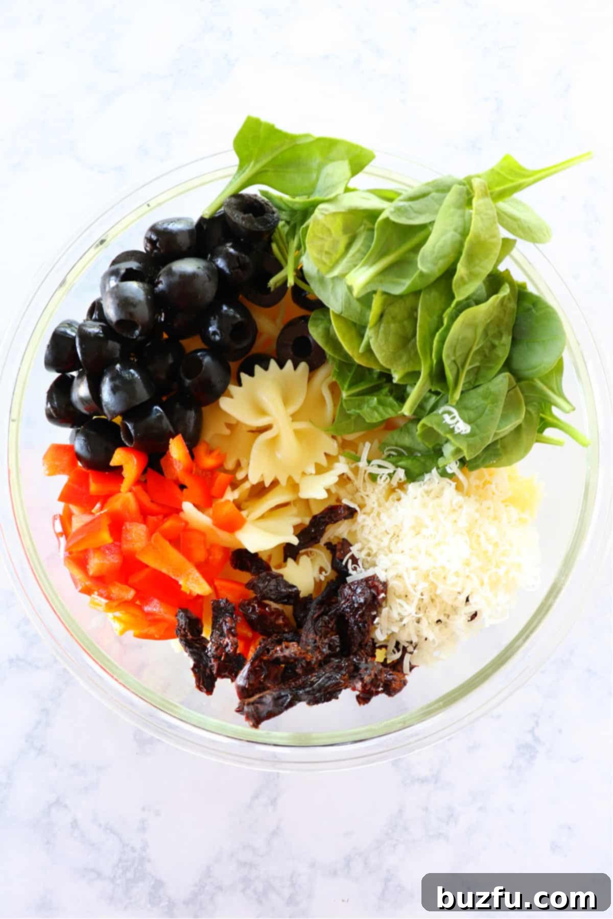 Mixing Tuscan Pasta Salad Ingredients All the vibrant ingredients for Tuscan pasta salad neatly combined in a large mixing bowl, ready for the dressing.