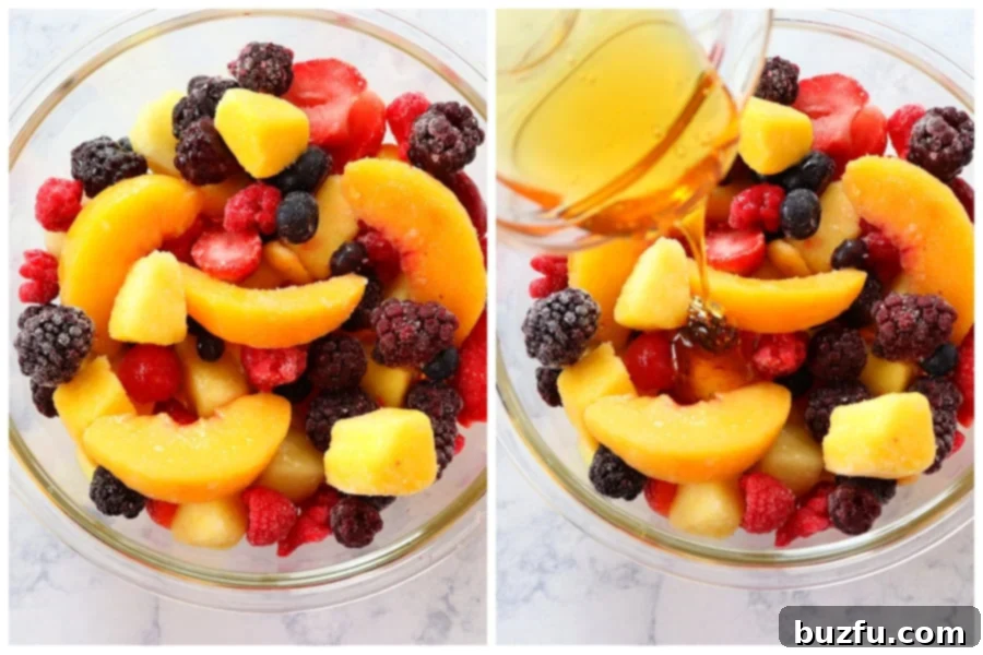 A person gently stirring a bowl of frozen fruit with honey and lemon juice, demonstrating the preparation process.