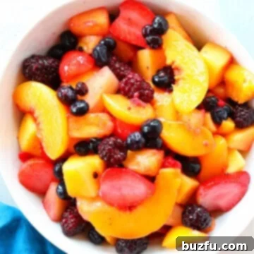 Overhead shot of fruit salad in white bowl.