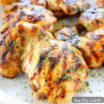 Grilled chicken thighs on a plate, perfectly cooked and ready to eat.