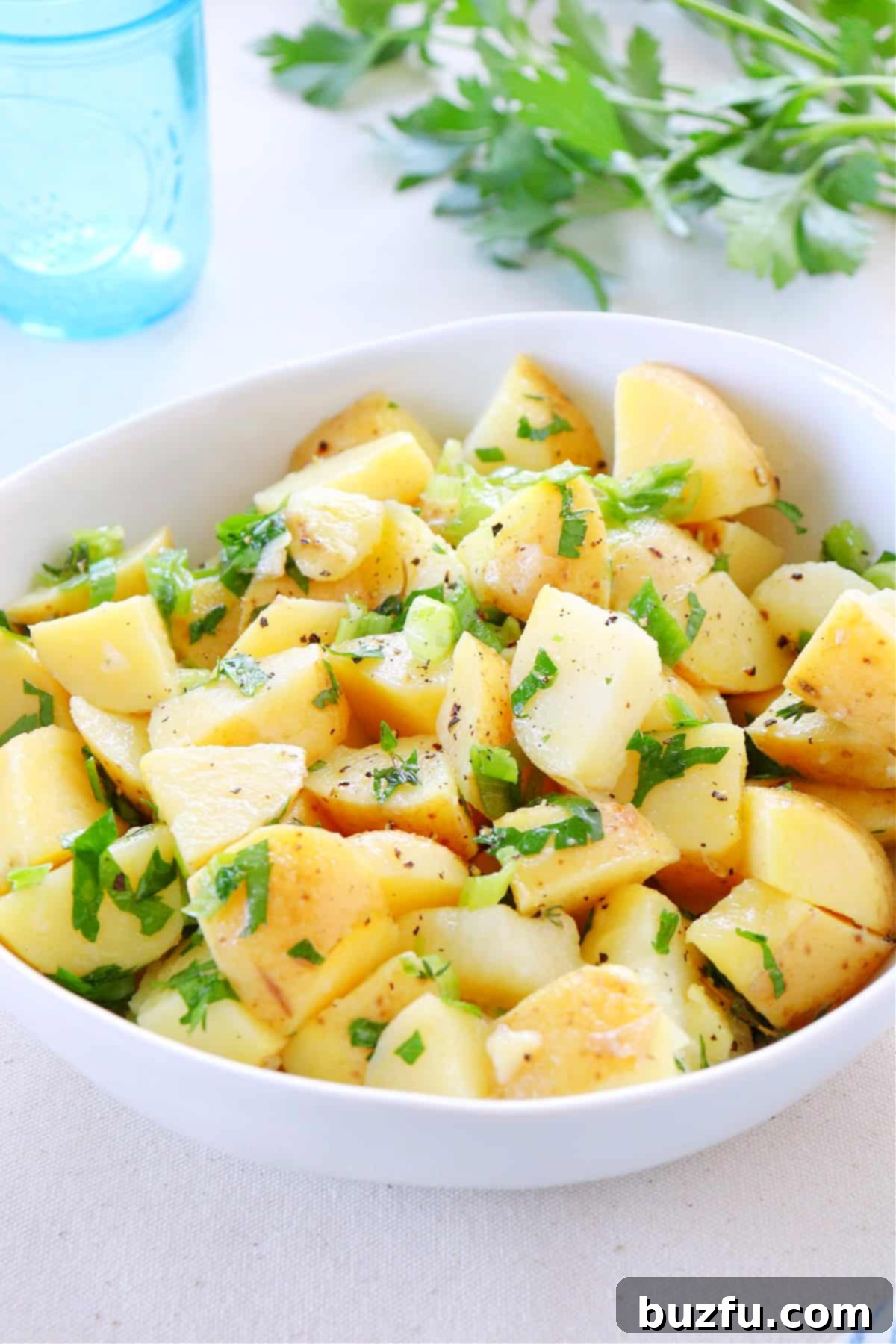 Potato salad in a white bowl.