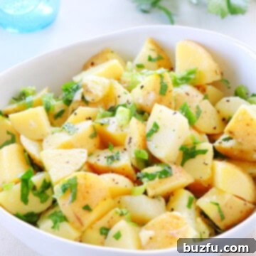 Potato salad in a white bowl.