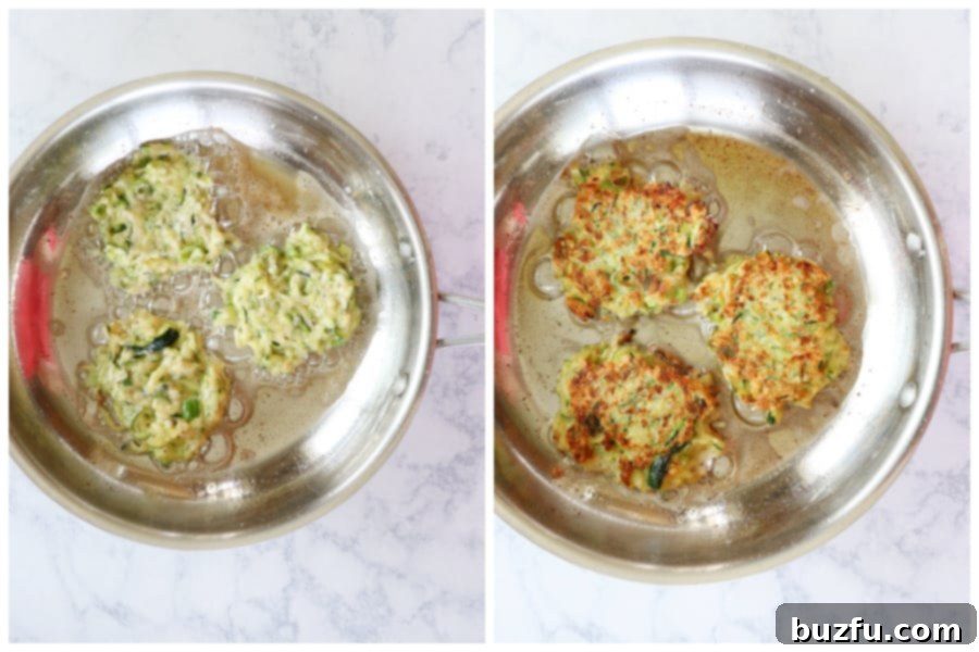 Frying Zucchini Fritters to Golden Perfection Close-up shot of several zucchini fritters sizzling and turning golden brown in a hot pan with olive oil.