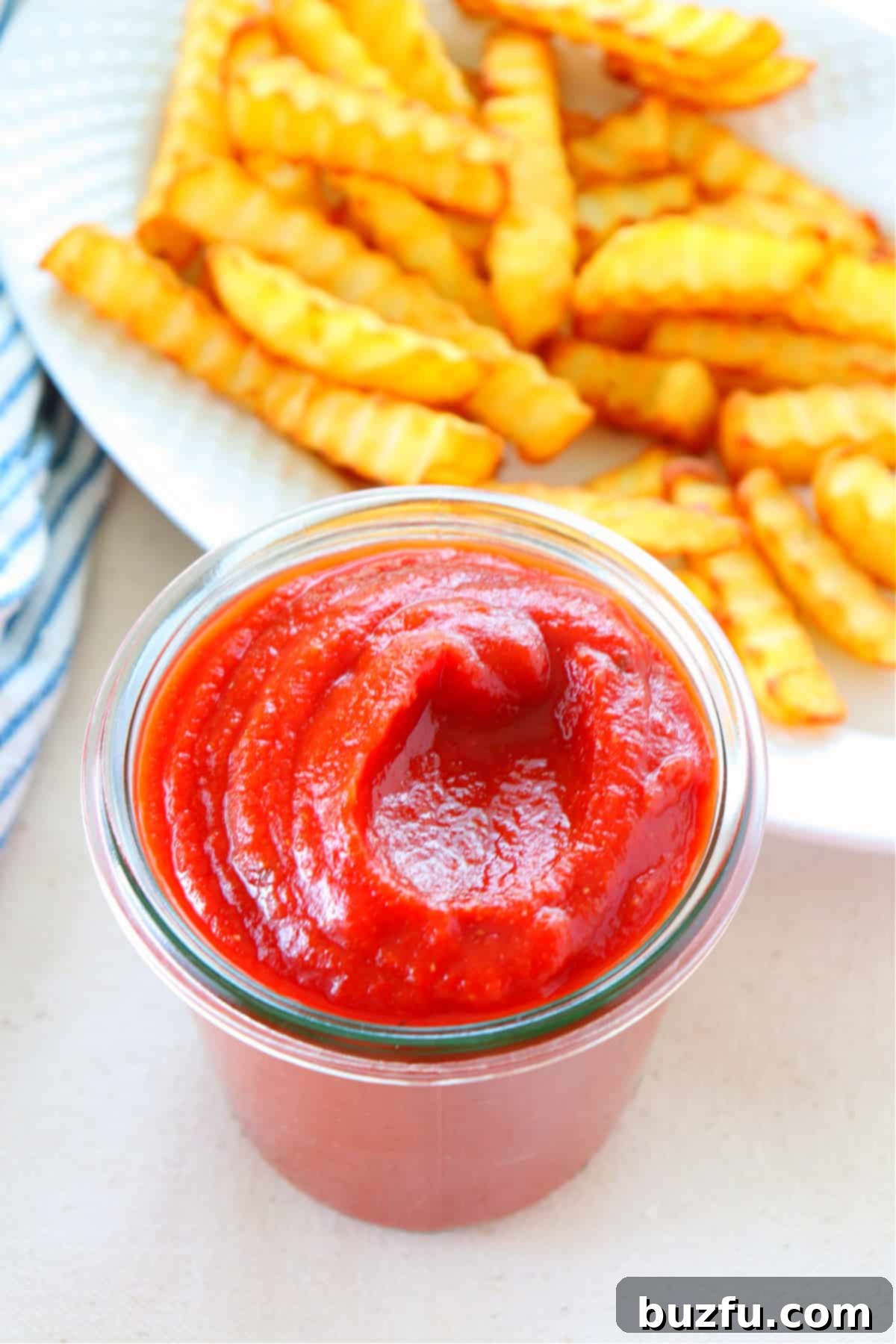Easy Homemade Ketchup Recipe without Sugar Freshly made homemade ketchup in a clear glass jar, ready to be served or stored.