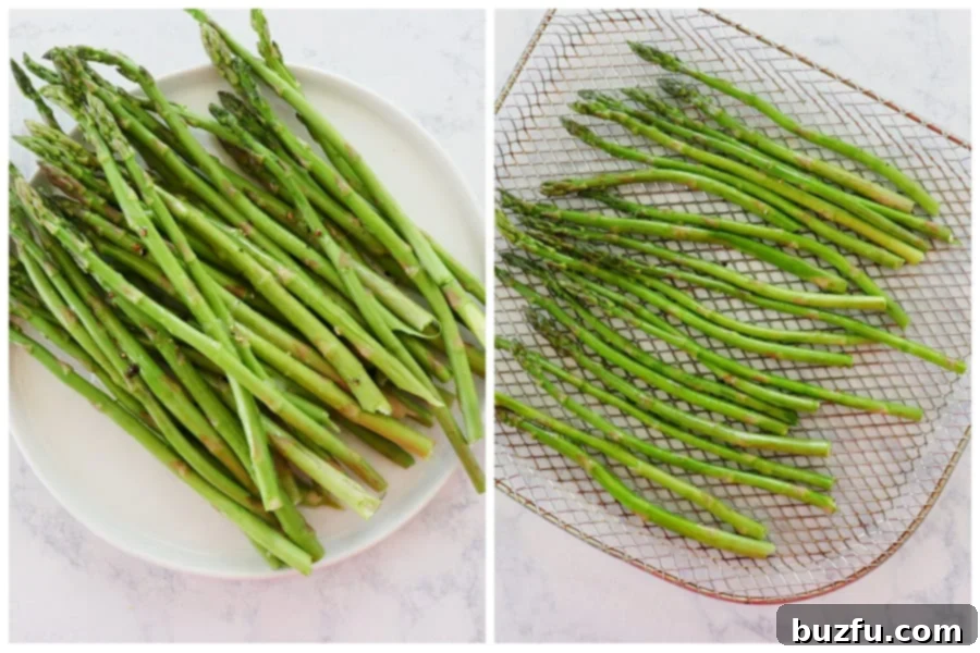 Seasoned asparagus spears arranged in a single layer on an air fryer rack, ready for cooking.