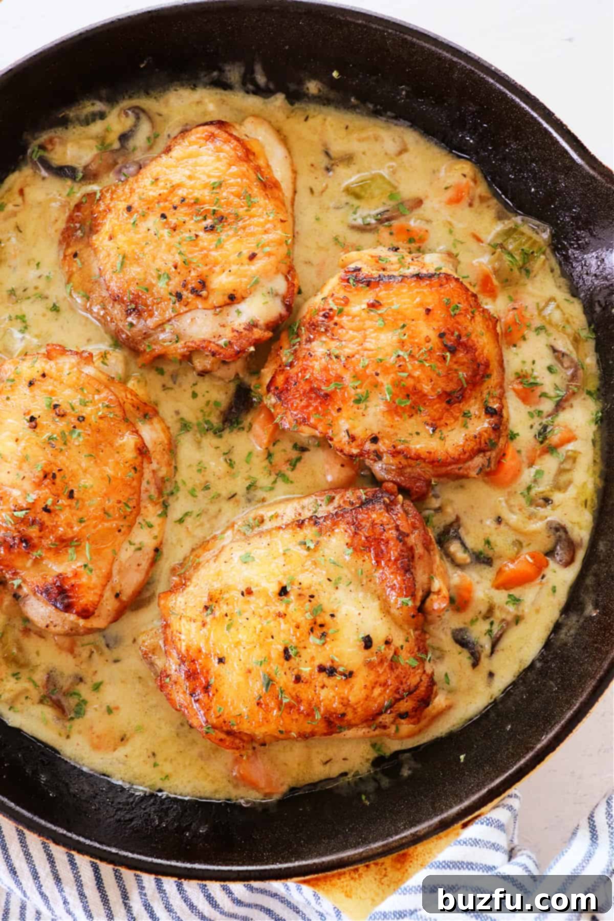 Easy Chicken Fricassee Recipe Chicken thighs in fricassee sauce in skillet.