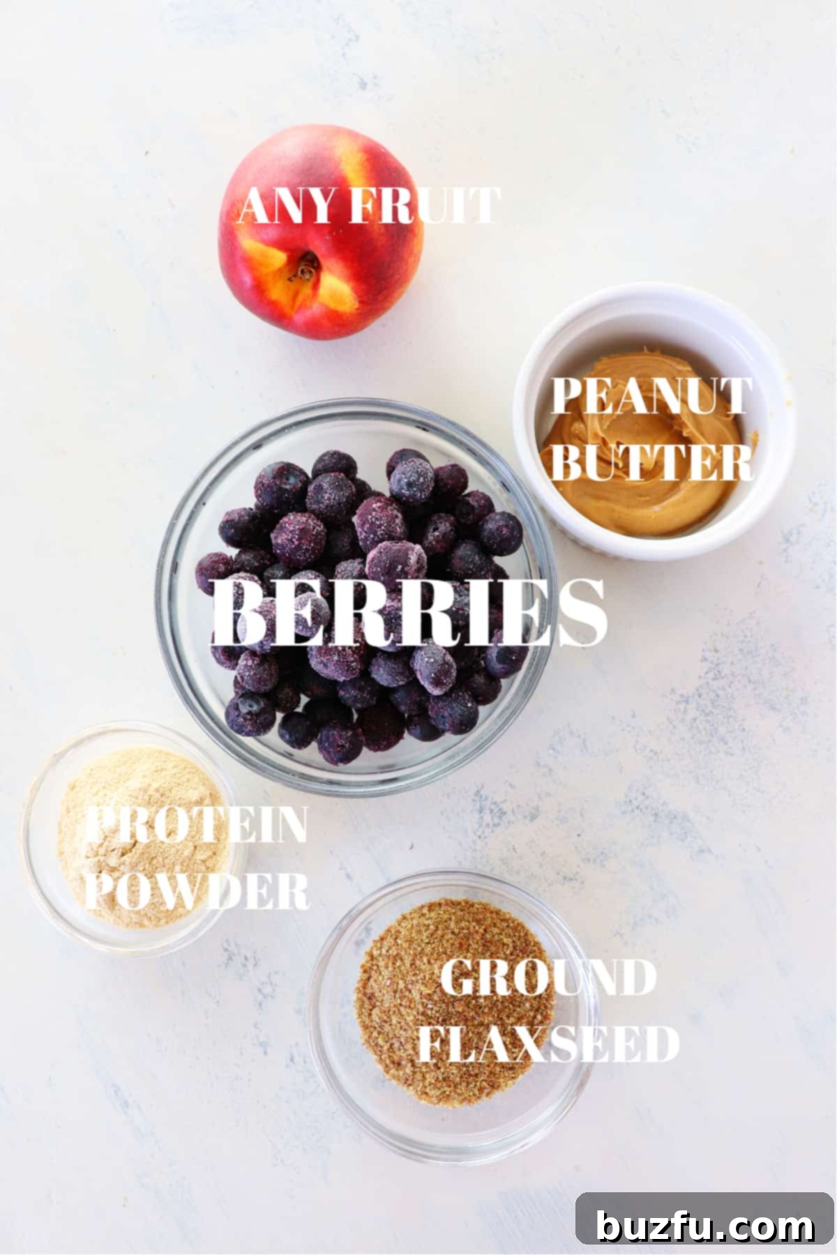 A vibrant selection of smoothie add-ins including fresh berries, various nuts, seeds, and nut butters, laid out beautifully on a wooden surface next to a glass of oatmeal smoothie, inviting endless customization.