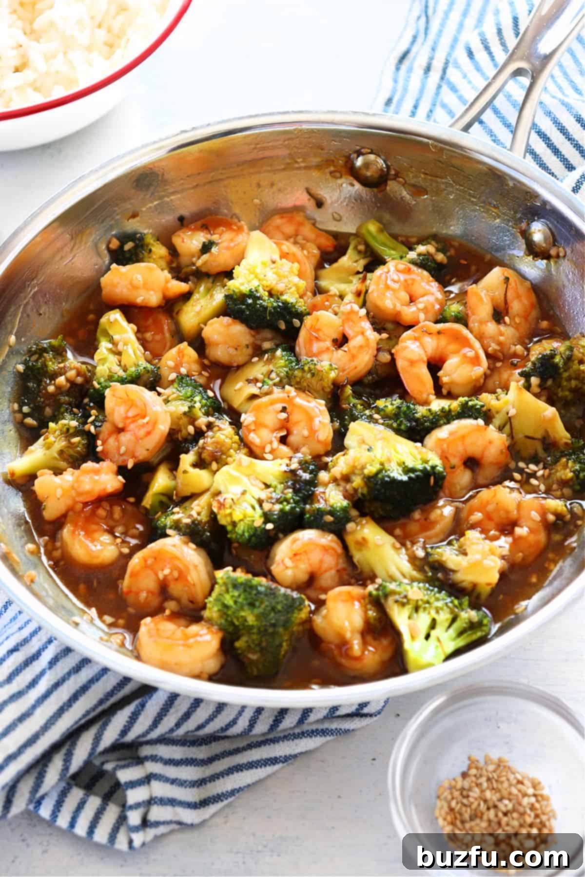 Vibrant shrimp and broccoli stir fry cooking in a large pan.