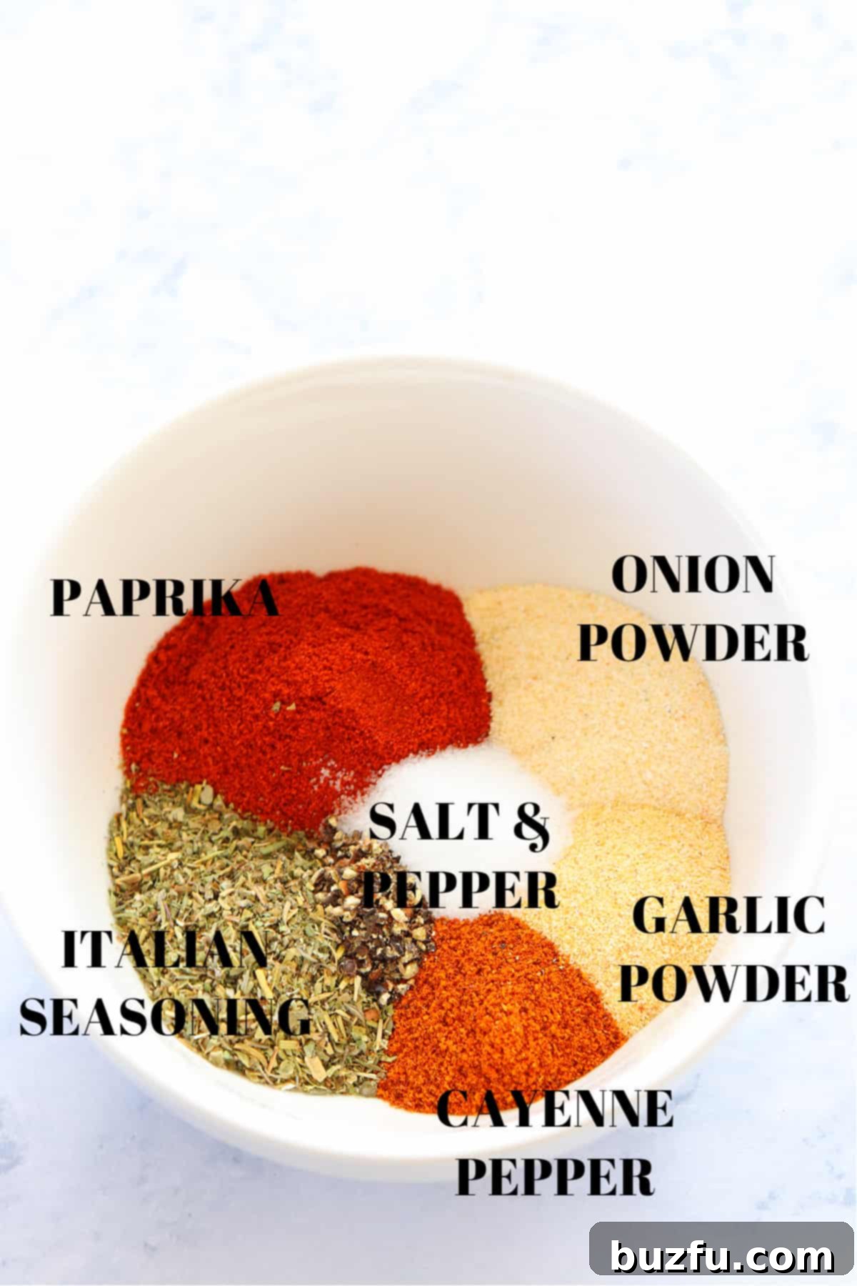 blackened seasoning ingredients Assortment of spices for the seasoning mix in a white bowl, showcasing their vibrant colors.