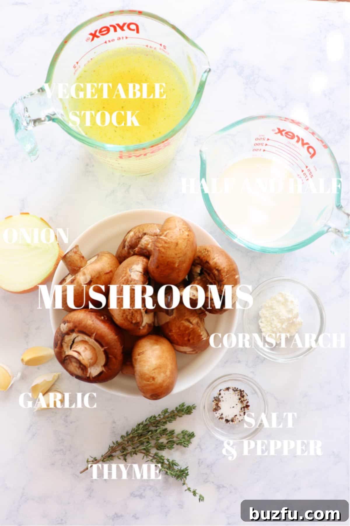 Fresh ingredients for mushroom soup laid out on a rustic marble board, including whole mushrooms, butter, onion, garlic, and thyme.
