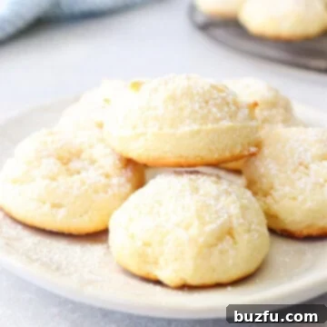 Cream cheese cookies on a small white plate, showing their soft texture.