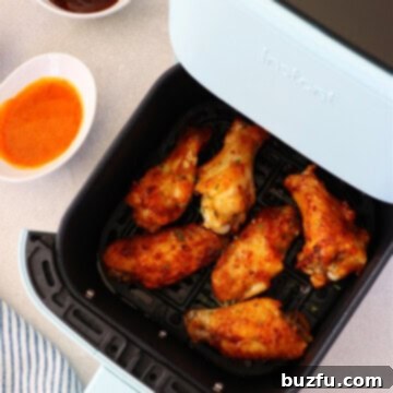 Air Fryer Wing Perfection 3 Crispy golden-brown chicken wings perfectly cooked in an air fryer basket, ready to be served.