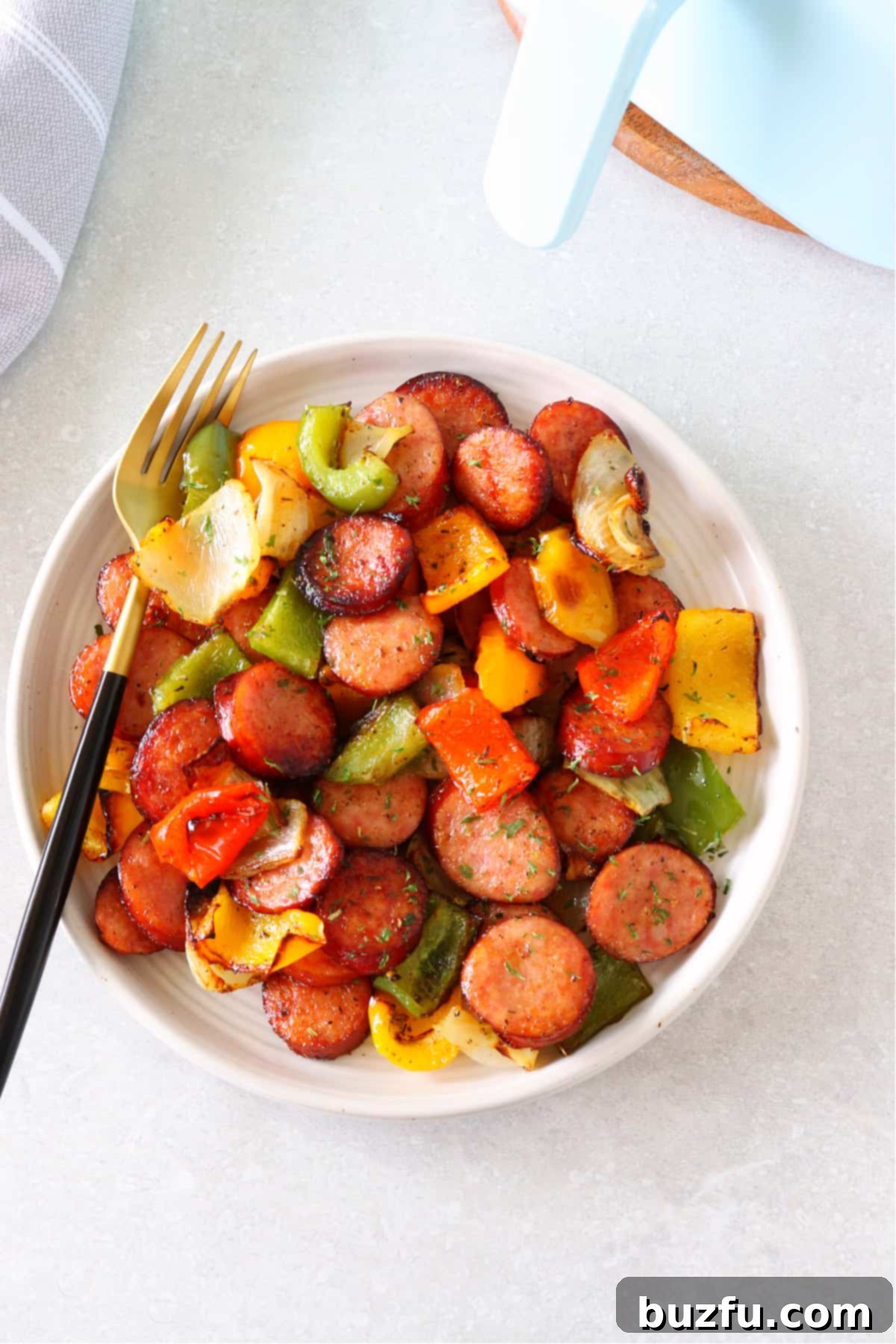 Air Fryer Sausage and Peppers recipe Air fried sausage and peppers on a plate with fork.