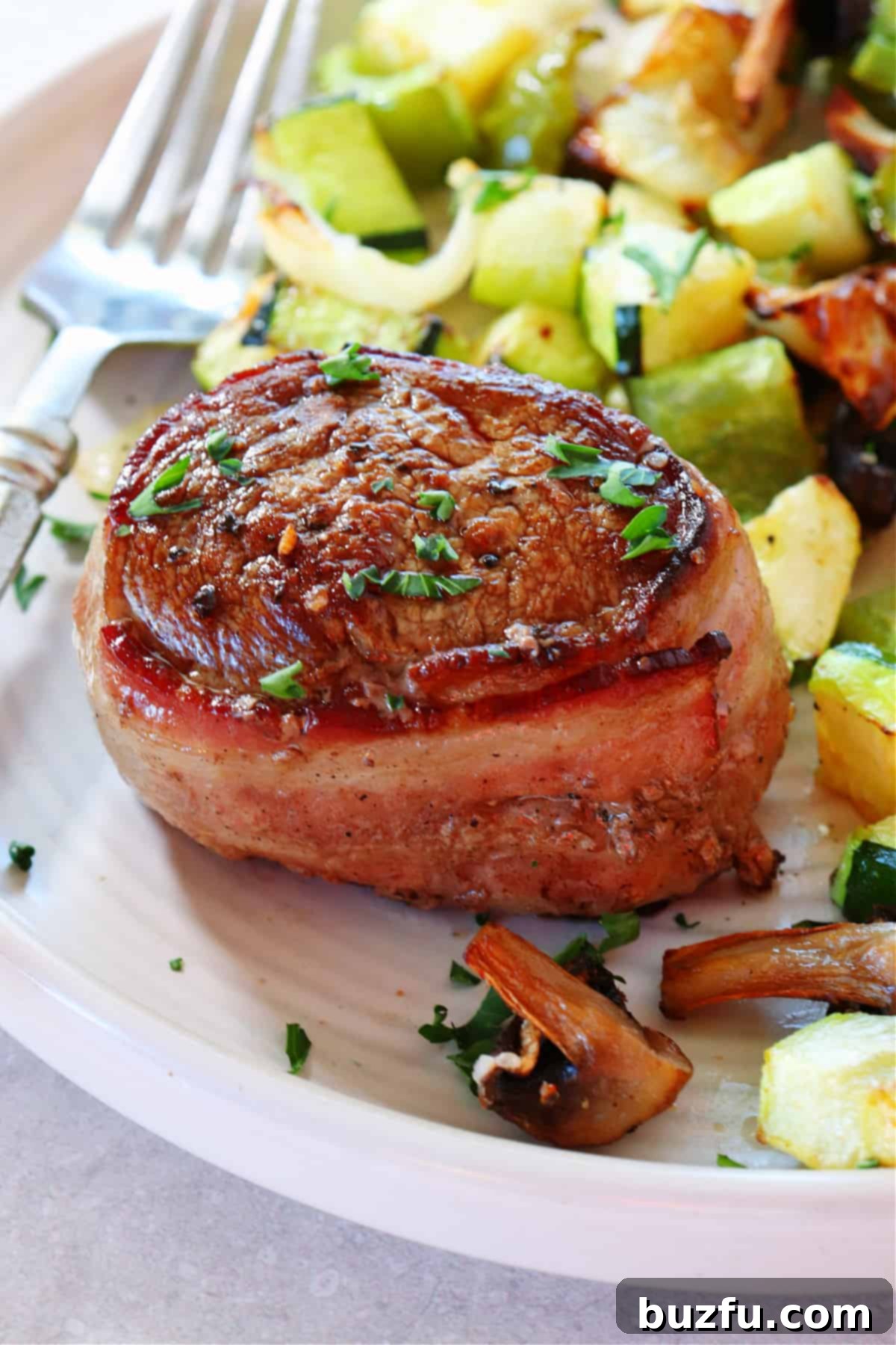 Filet mignon with roasted vegetables on a plate, ready to be served.