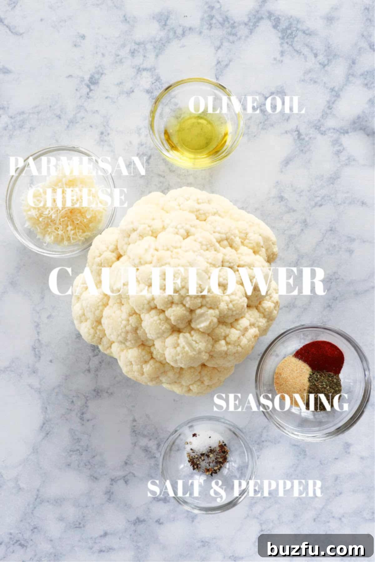 Cauliflower Steaks Ingredients Selection Fresh head of cauliflower and other essential ingredients laid out on a marble board for preparation.