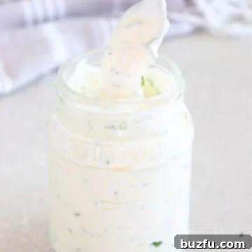 Homemade Ranch Magic 3 Ranch dressing in a glass jar with spoon.