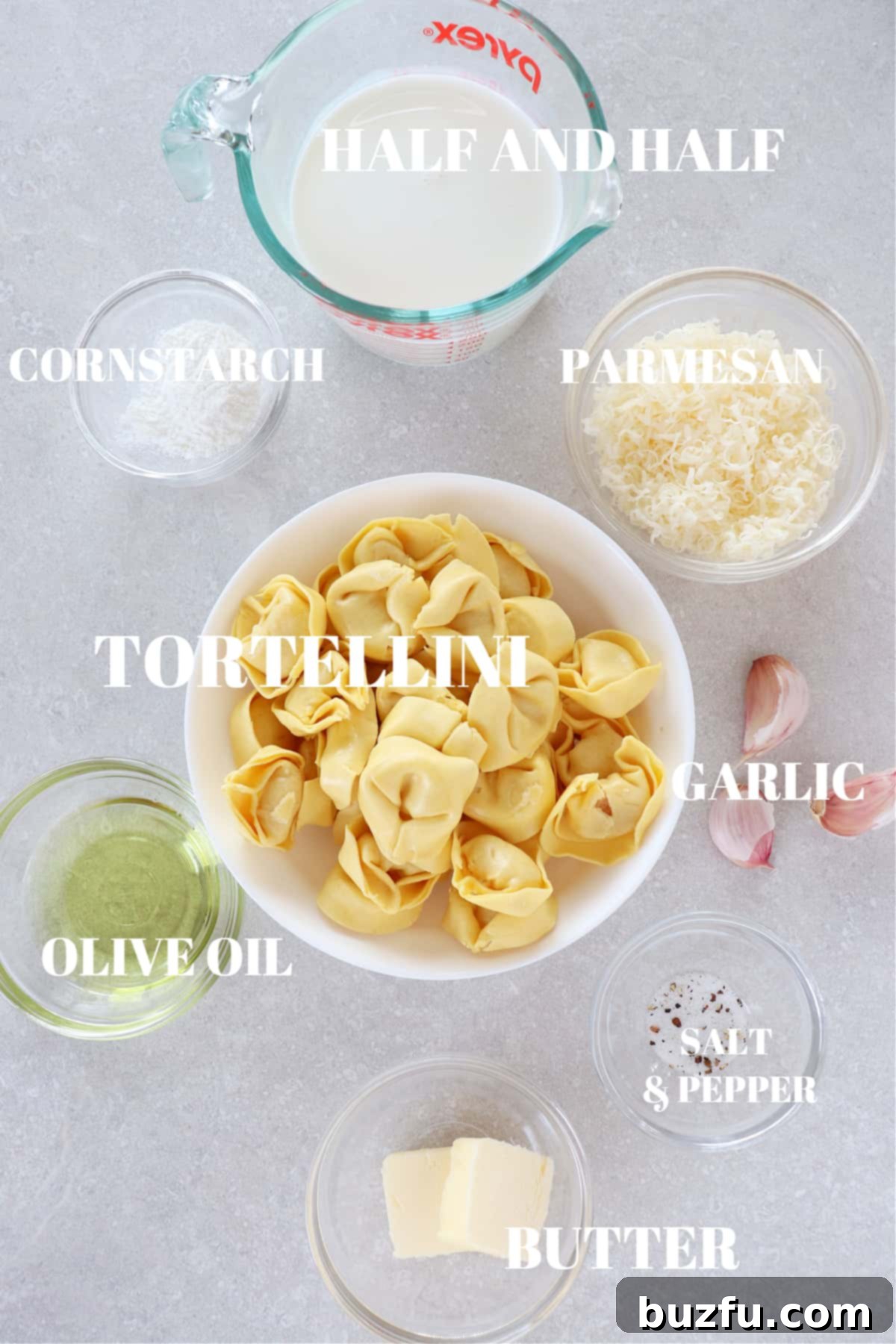 Ingredients for Tortellini Alfredo laid out on a wooden cutting board.