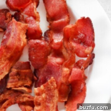 Cooked bacon on white plate.