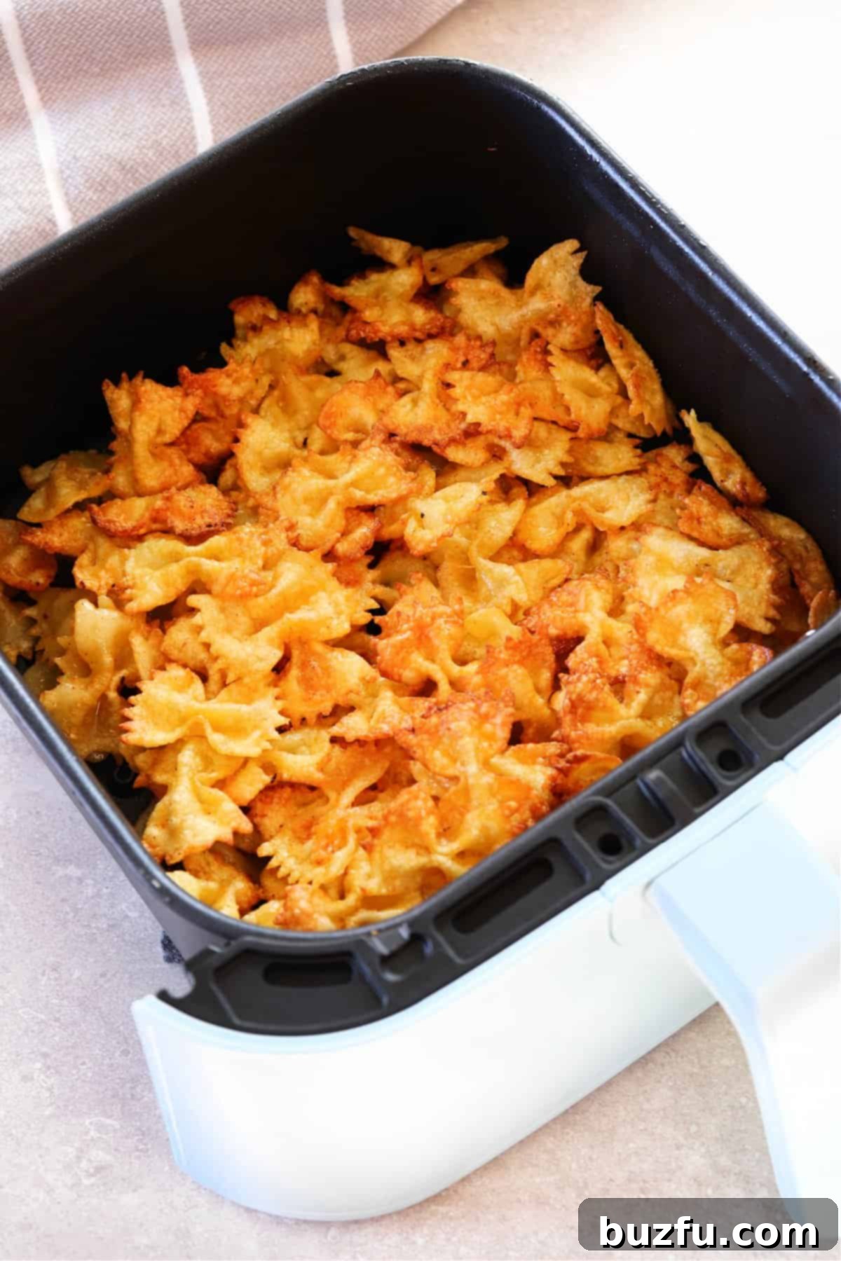 Air Fryer Pasta Chips Recipe Crispy fried pasta chips in an air fryer basket, ready to be served as a delicious snack.