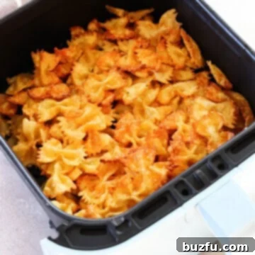 Crunchy Air Fryer Pasta Bites 3 Fried pasta in air fryer basket, showing crispy texture and golden color.