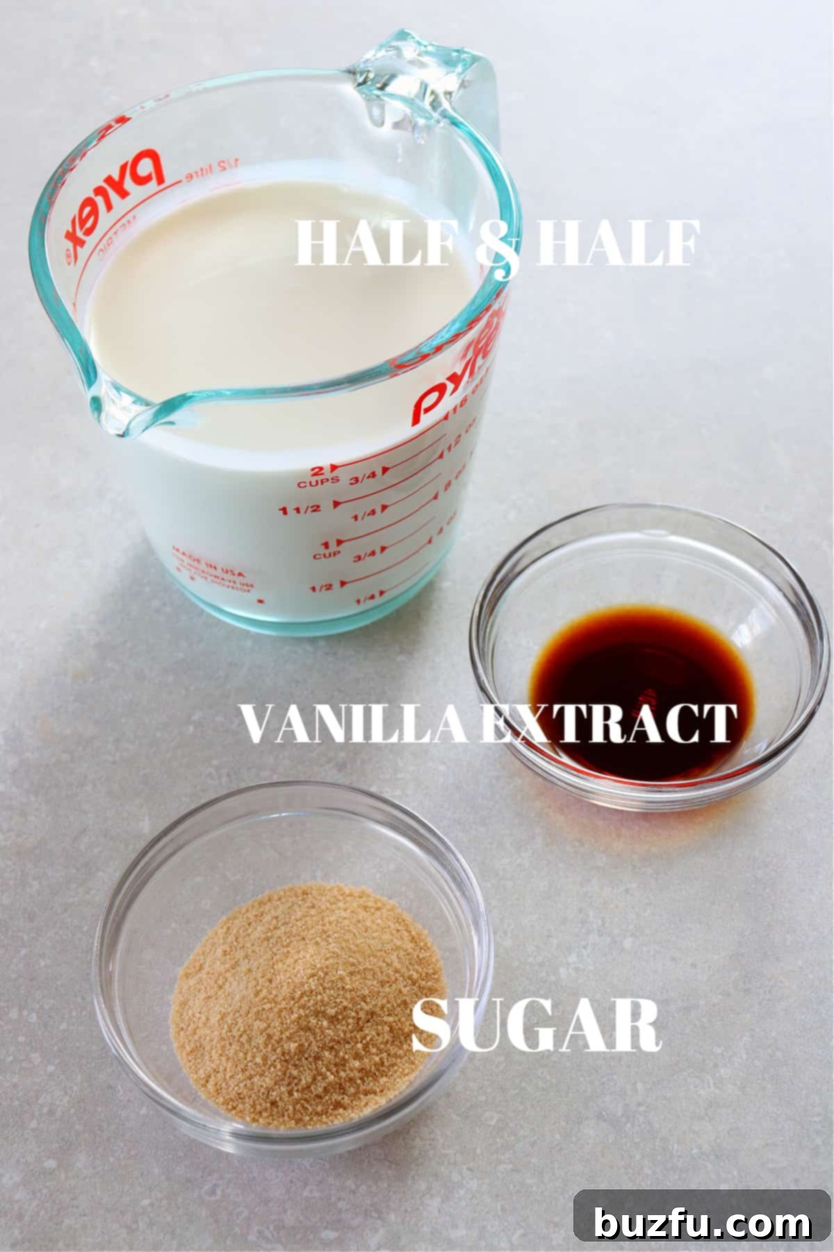 Three key ingredients for homemade coffee creamer: a carton of half and half, a bowl of brown sugar, and a bottle of vanilla extract, artfully arranged on a wooden board.