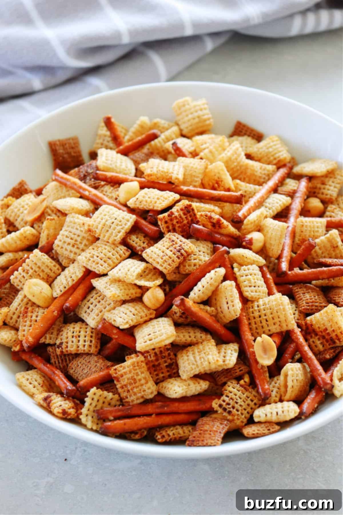 Party mix in a white serving bowl.