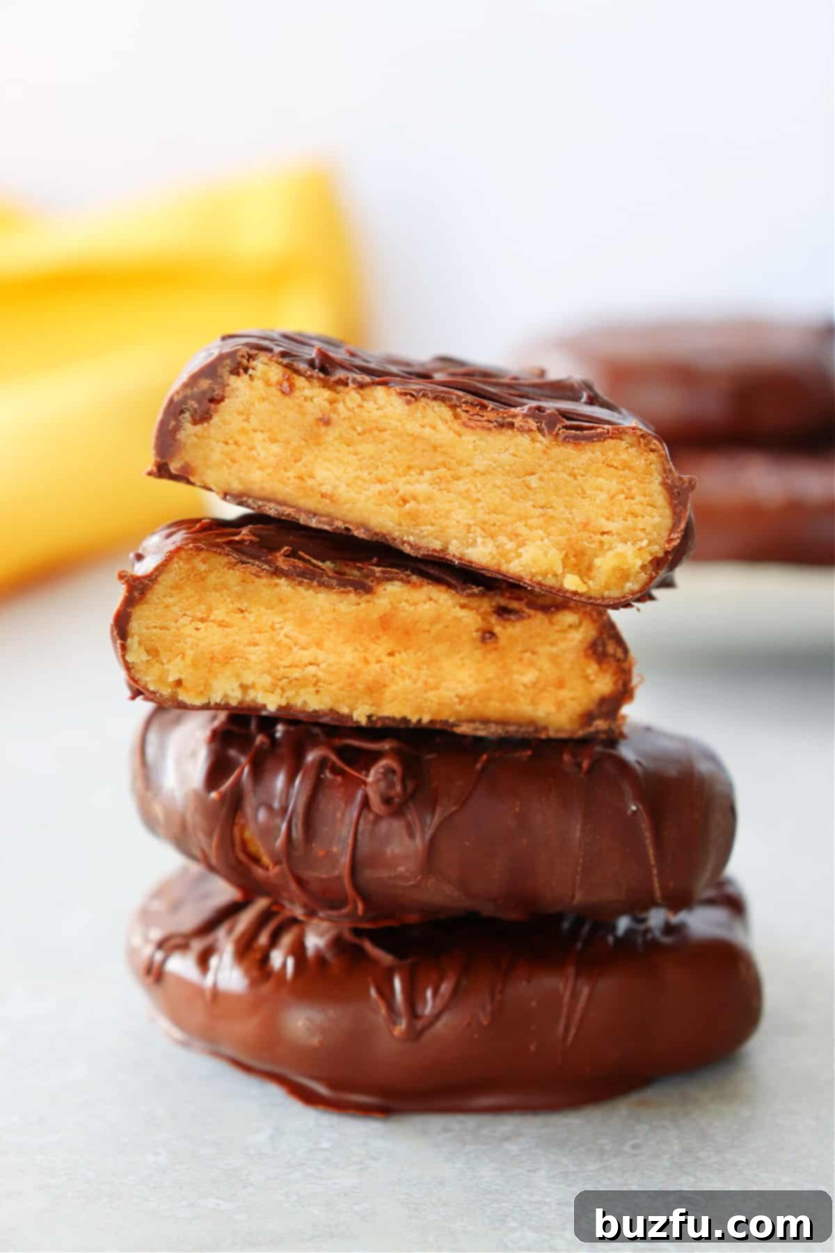 Homemade Reese's Style Peanut Butter Easter Eggs Recipe Peanut butter eggs stacked on a board, showcasing the rich chocolate coating and golden peanut butter interior.