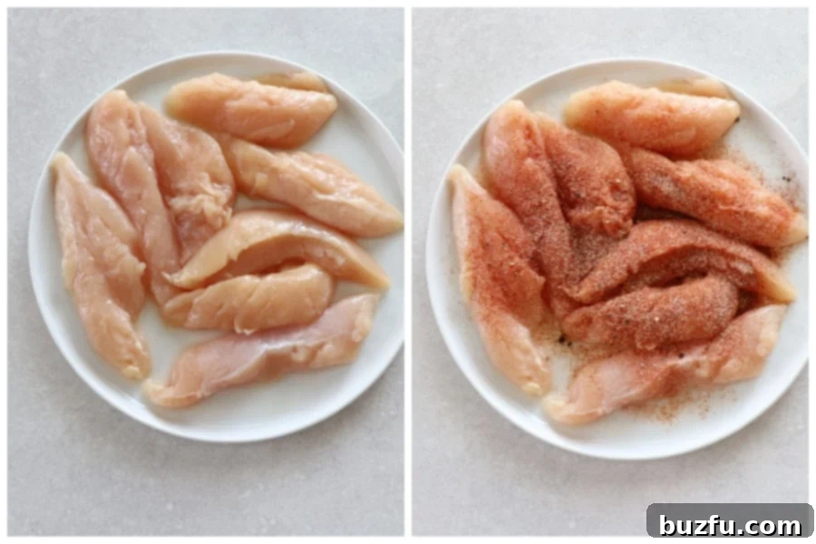 Raw chicken tenders seasoned with spices, laid out on a white plate, ready for breading.