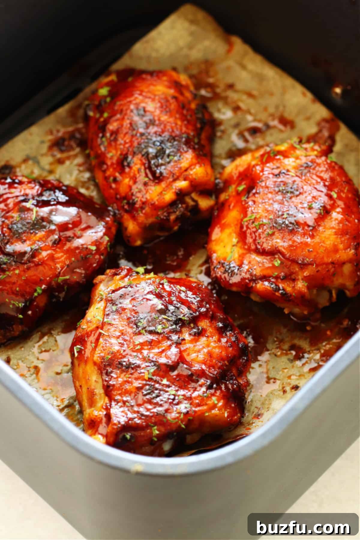 Air Fryer BBQ Chicken Thighs: Juicy and Crispy Perfection Chicken thighs with BBQ sauce perfectly cooked in an air fryer basket, ready to be served.