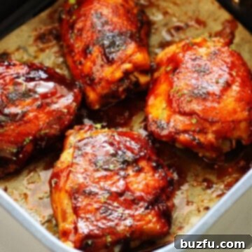 Crispy Air Fried BBQ Chicken Thighs 3 Chicken thighs with BBQ sauce in the air fryer basket.