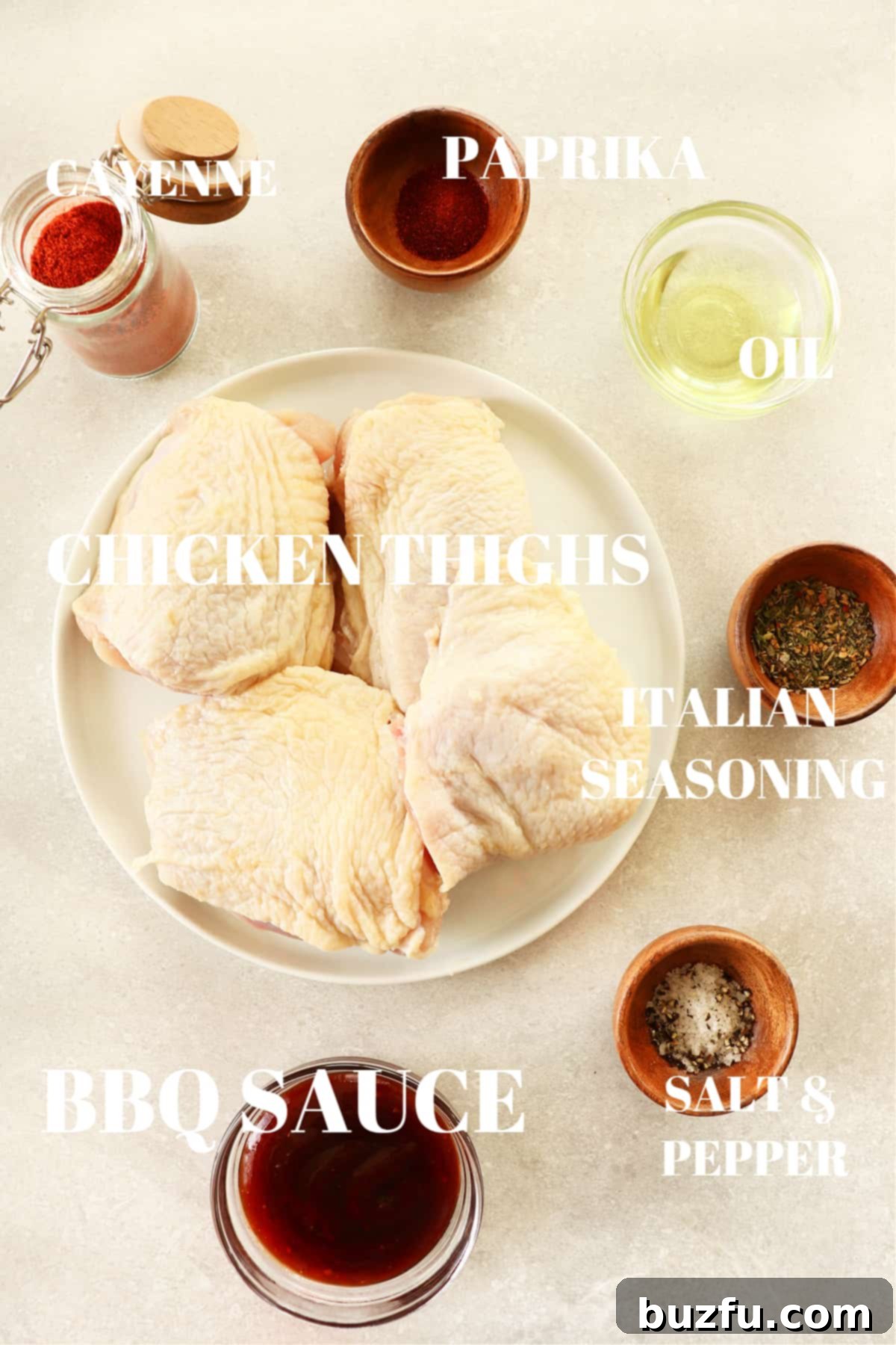 Air Fryer BBQ Chicken Thighs Ingredients A selection of fresh ingredients including chicken thighs, spices, and BBQ sauce laid out on a rustic photography board.