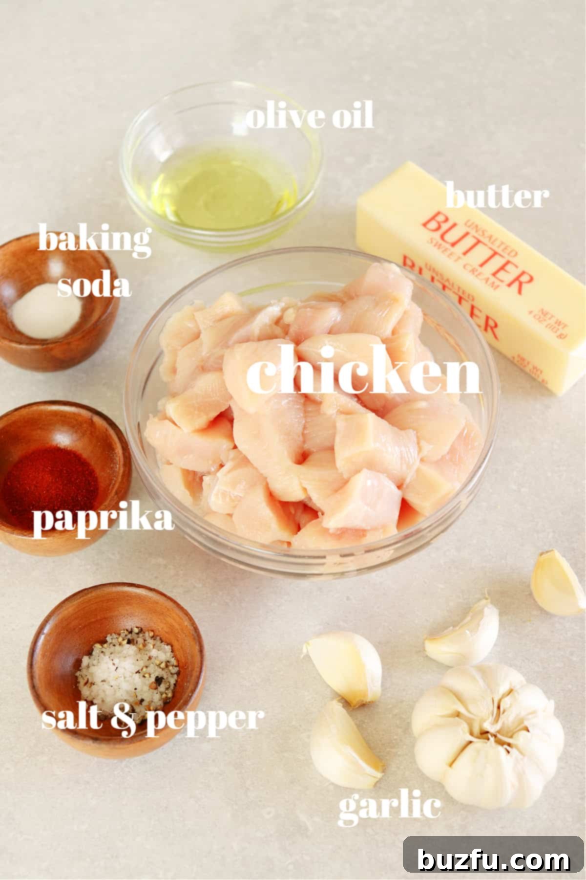 Garlic Butter Chicken Ingredients Arrangement of fresh ingredients for garlic butter chicken recipe on a rustic gray board.