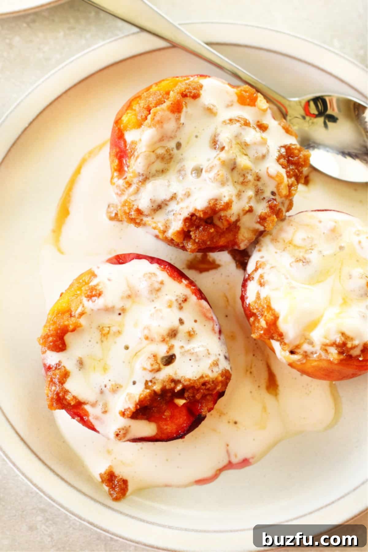 Air Fryer Peaches: A quick and delightful summer dessert, perfectly air-fried and garnished. Three halves of air fryer peaches with whipped cream and a delicate drizzle of caramel on a crisp white plate, elegantly presented and ready to be enjoyed.