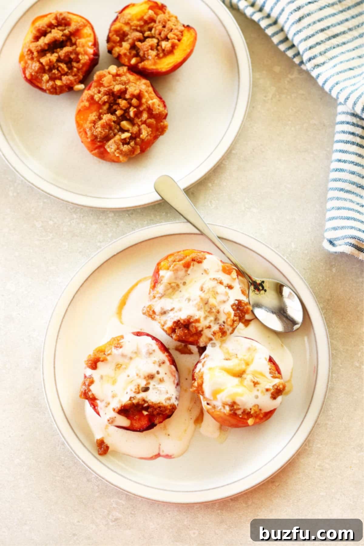A delightful 10-minute Air Fryer Peach dessert, perfectly portioned and ready to be savored. Two white plates, each presenting a single serving of air-fried peach halves topped generously with fluffy whipped cream, captured from an inviting, close-up angle.