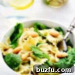 Pasta and spinach in white bowl.