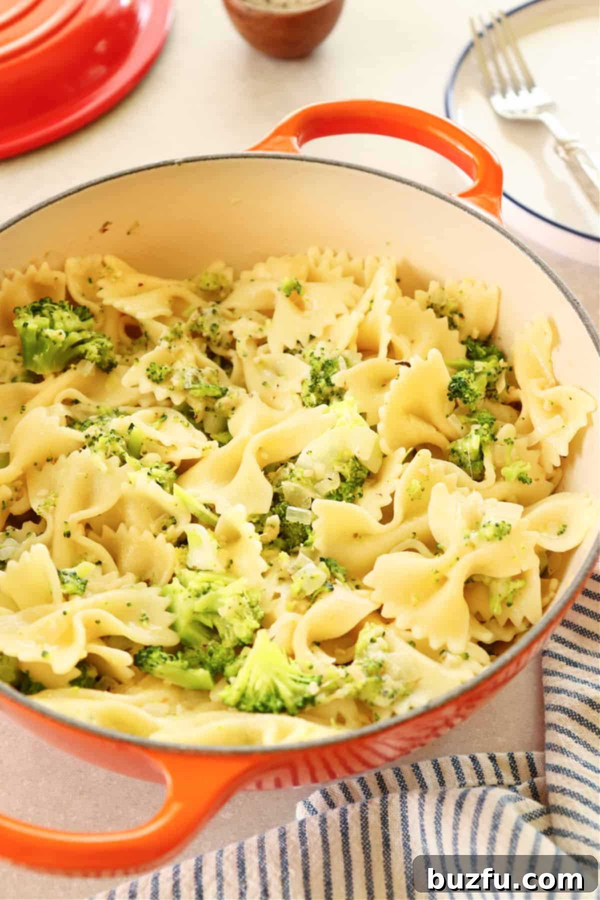 Broccoli pasta served in a rustic Le Creuset pan, showcasing vibrant green broccoli florets mixed with golden pasta.