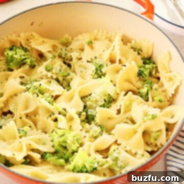 Broccoli pasta served in a rustic Le Creuset pan, showcasing vibrant green broccoli florets mixed with golden pasta.