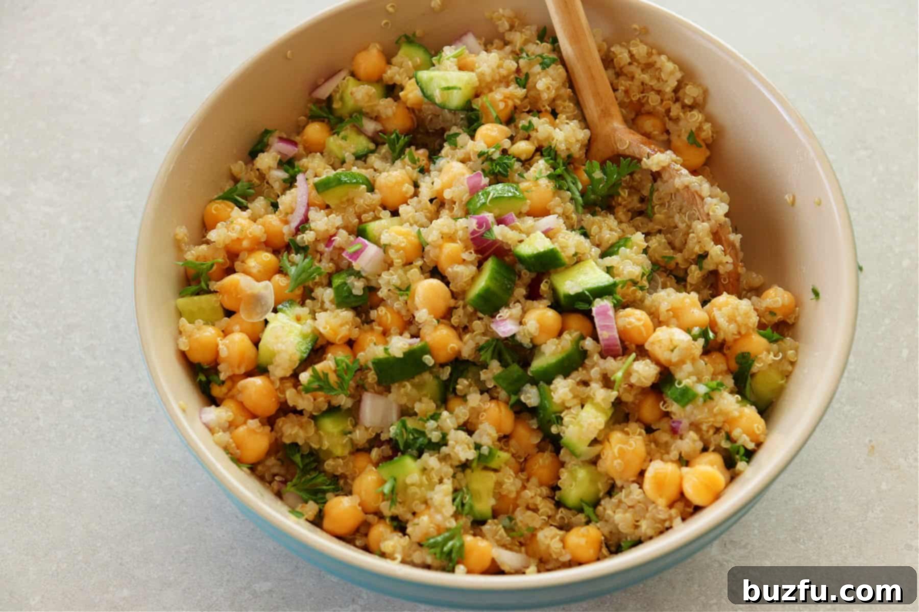 Salad with quinoa, chickpeas and cucumber in a mxing bowl.